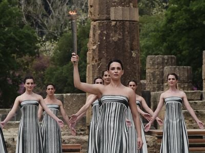 Greek actor Mary Mina played the role of the high priestess at the ceremony, which took place in Olympia in front of the ruins of the temple of Hera.